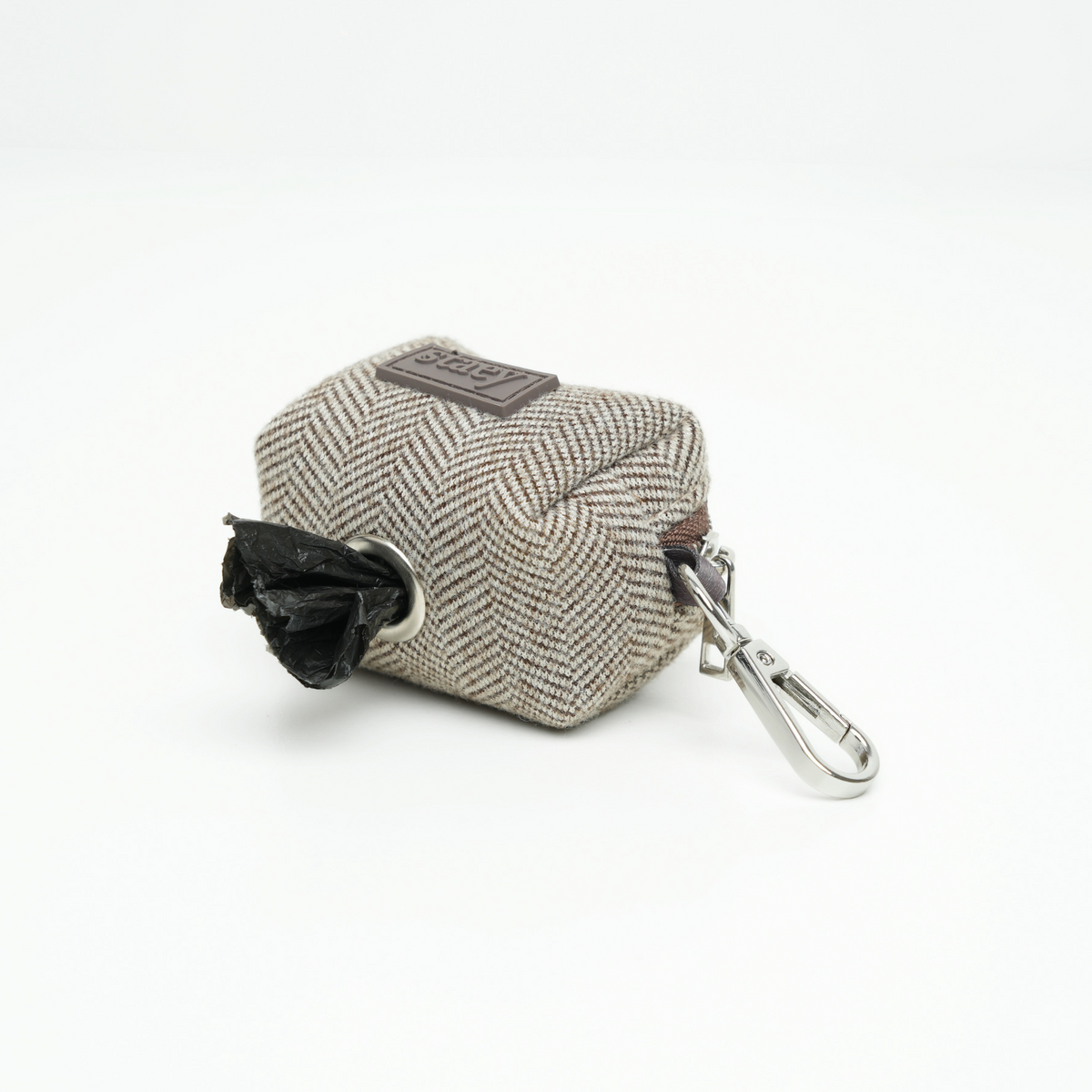 Elma poop bag holder dispensing a waste bag through its opening