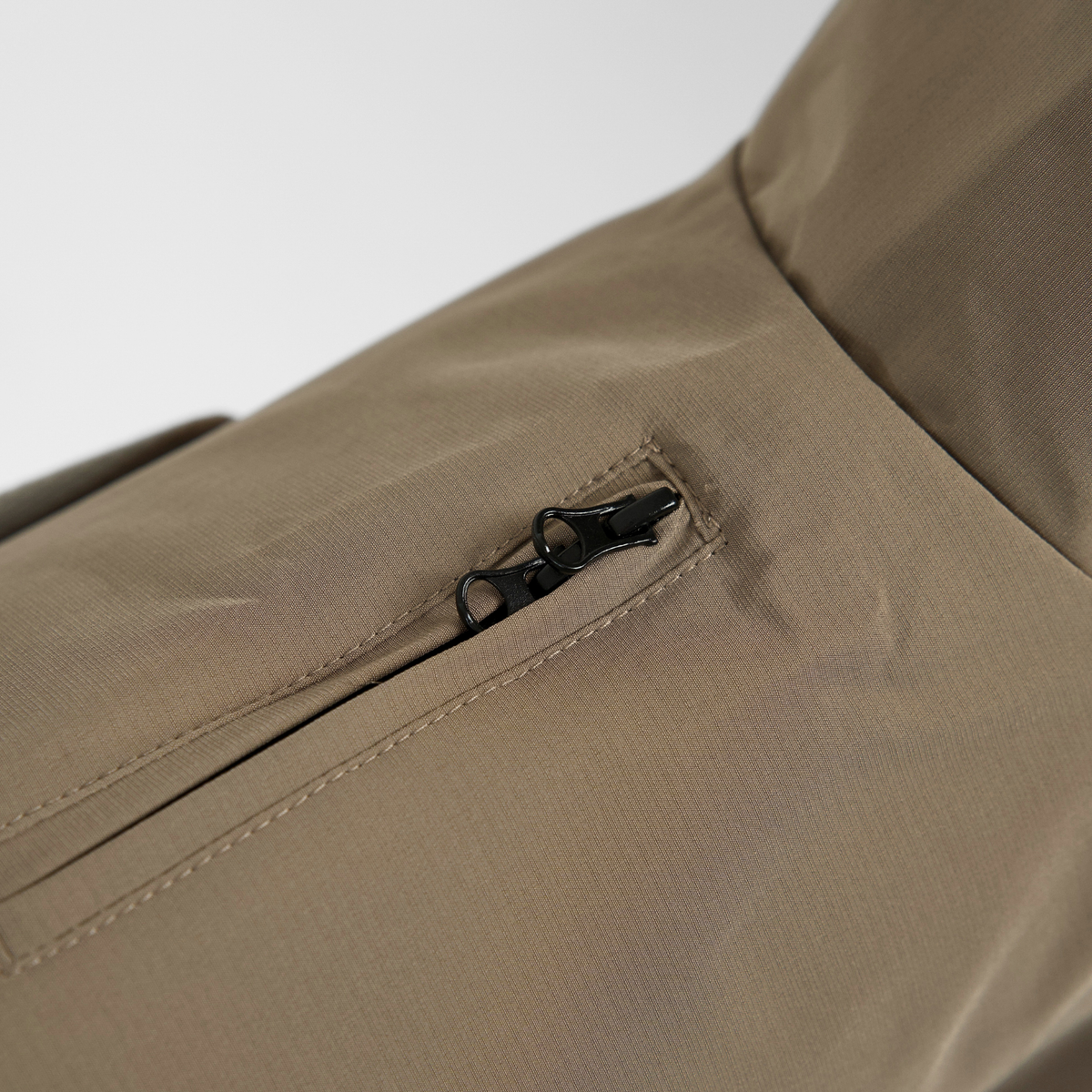 Close-up of the zip pocket on the taupe dog rain coat