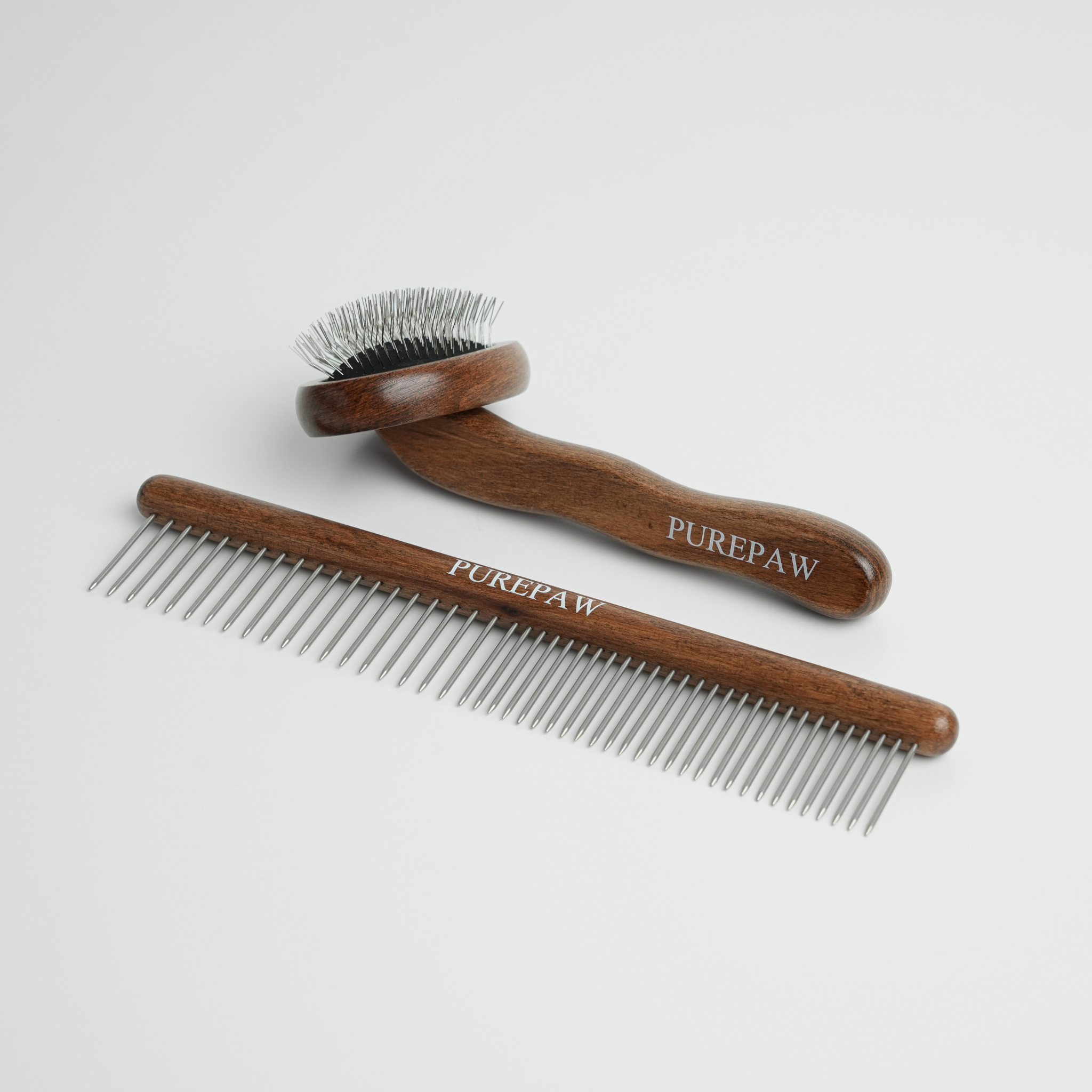 Two wooden dog grooming tools with metal teeth on a light gray background, branded 'PUREPAW'.