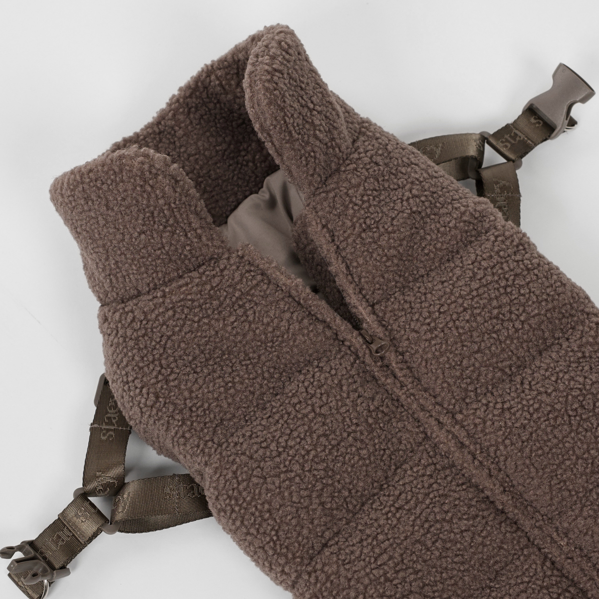 Le manteau pour chien en peluche couleur taupe avec harnais, posé à plat