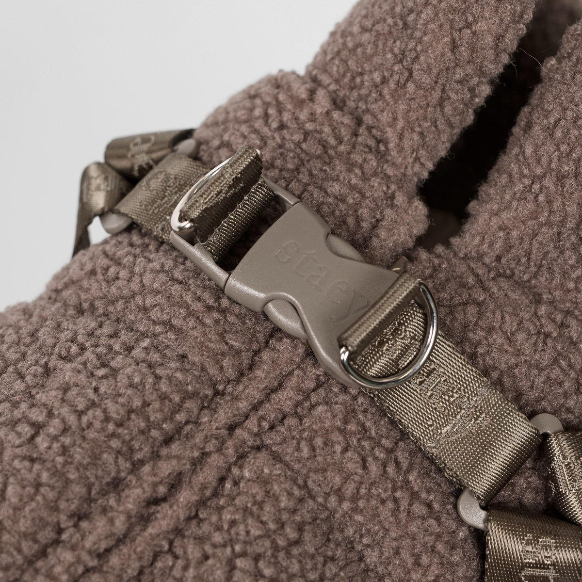 Gros plan sur la boucle du harnais du manteau pour chien « teddy » couleur taupe