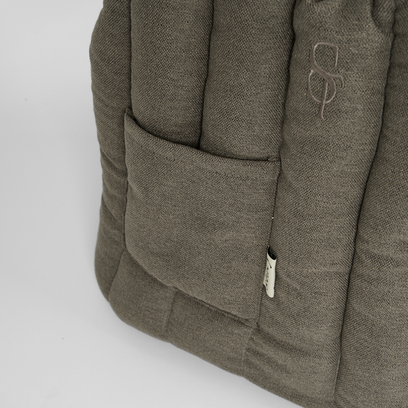Close-up of the front pocket and zip on the olive teddy carrier bag