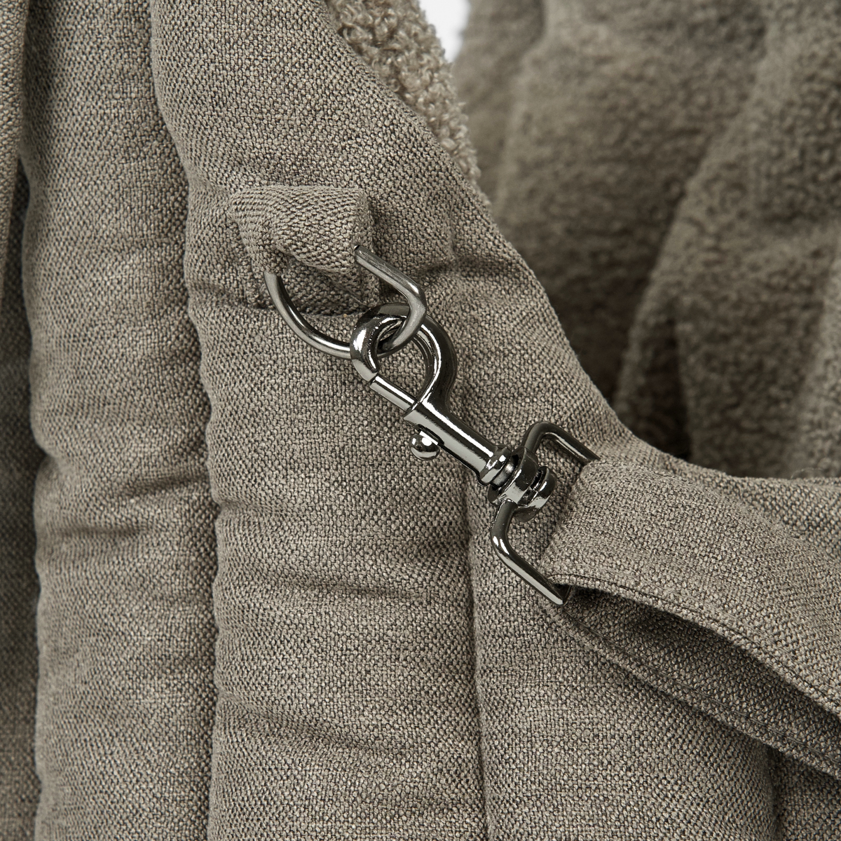 Close-up of the safety-leash clip inside the olive teddy carrier bag