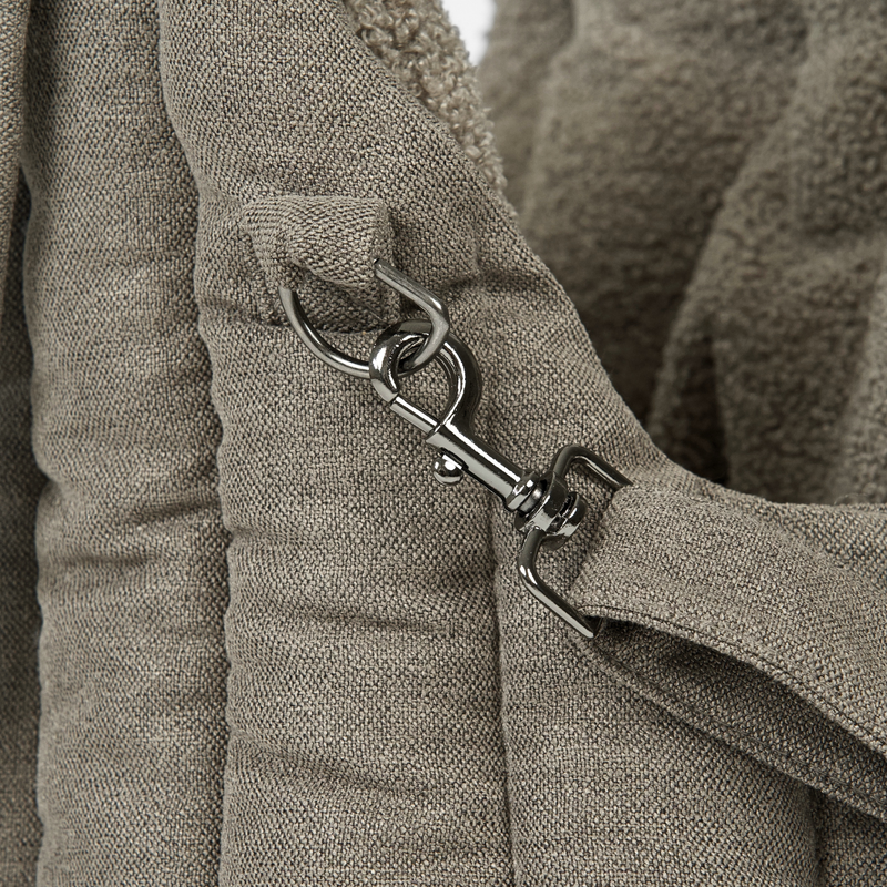 Close-up of the safety-leash clip inside the olive teddy carrier bag