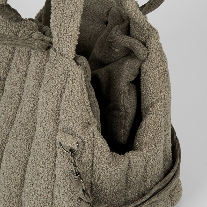 The olive teddy carrier bag open, showing its safety leash