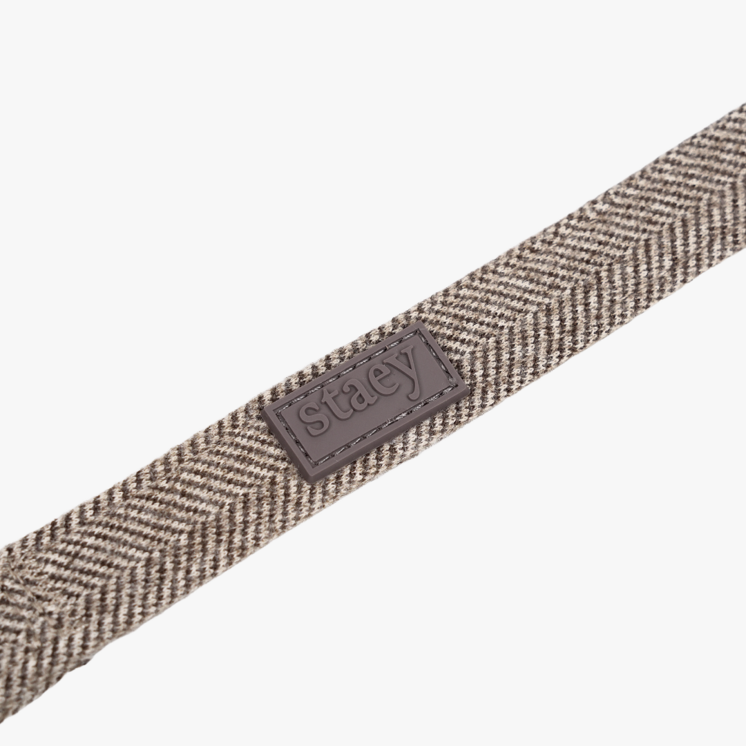 Gros plan sur la sangle à motif Herringbone couleur Mocca et l'étiquette Staey